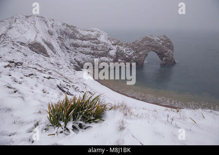 Il 18 marzo 2018. Una sorprendente serie di bufera di neve spazzato tutta la contea del Dorset per tutta la notte e la mattina. La bellissima formazione rocciosa naturale, porta di Durdle situato su Jurassic Coast è coperto in una spolverata di neve. Nevica raramente nel Dorset, e questo anno ha nevicato due volte in una quindicina di giorni. Credito: Wayne Farrell/Alamy News Foto Stock