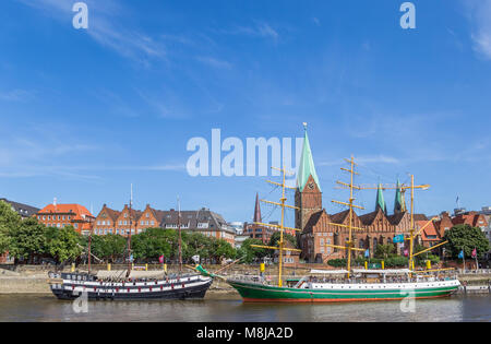 Navi storiche e chiesa lungo il fiume Weser di Brema, Germania Foto Stock