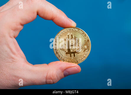 Golden Bitcoin Cryptocurrency in mano d'uomo. Nuovo denaro virtuale concetto. Foto Stock