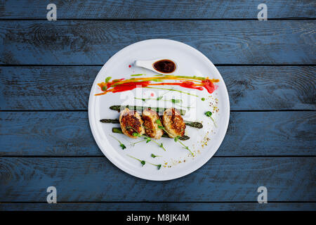 Cotolette di pollo con asparagi in salsa di vino. Foto Stock