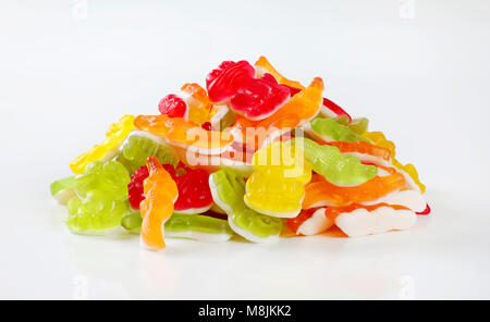 Pila di colorate caramelle gommose a forma di animali su sfondo bianco Foto Stock