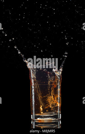 Colpo isolato di whiskey con splash su sfondo nero Foto Stock