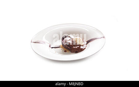 Scoop di gelato al cioccolato,brownie fatti in casa con gelato sulla sommità e salsa al cioccolato sono topping isolato su bianco. Foto Stock