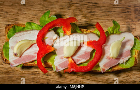 Sandwich con pancetta e verdure su sfondo di legno Foto Stock