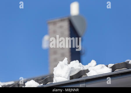 La neve sul tetto di una casa sulla giornata di sole in primavera Foto Stock