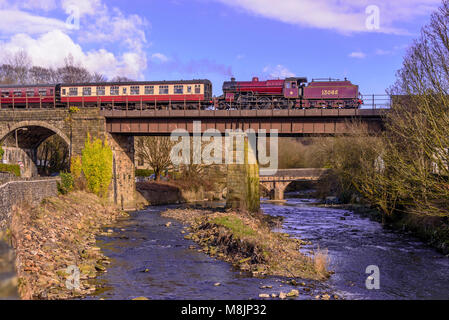 Il Mogul locomotiva a vapore del granchio raffigurata sul East Lancashire incrocio ferroviario il Brooksbottom viadotto sul fiume Irwell. Foto Stock