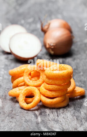 Croccanti anelli di cipolla fritti sul tavolo di legno Foto Stock