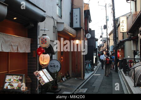 Unidentified i visitatori e i turisti in visita a un affascinante e tipica stradina nel Pontocho area del centro cittadino di Kyoto, Giappone al crepuscolo. Foto Stock