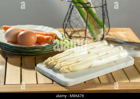 Materie non cotti bianco e verde di asparagi con uova e carote, pronto a cucinare per la cena Foto Stock