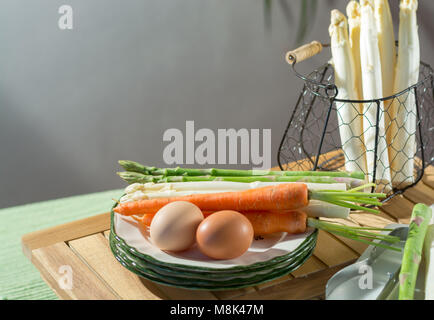 Materie non cotti bianco e verde di asparagi con uova e carote, pronto a cucinare per la cena Foto Stock