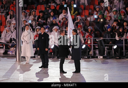 Presidente del Comitato Paralimpico Internazionale Andrew Parsons mano la Bandiera Paralimpica al sindaco di Pechino Chen Jining durante la cerimonia di chiusura per il PyeongChang 2018 Paralimpiadi Invernali in Corea del Sud. Foto Stock