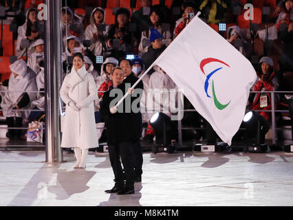 Presidente del Comitato Paralimpico Internazionale Andrew Parsons sventola la Bandiera Paralimpica al sindaco di Pechino Chen Jining durante la cerimonia di chiusura per il PyeongChang 2018 Paralimpiadi Invernali in Corea del Sud. Foto Stock