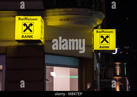 SARAJEVO, BOSNIA - 17 febbraio 2018: logo Raiffeisen sulla loro banca principale a Sarajevo, scattata di notte. La Raiffeisen è una banca austriaca, investire massicciamente Foto Stock
