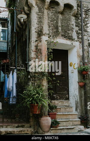 Italiano scena di strada con ingresso a casa e stendibiancheria fuori a Sermoneta, Latina, Italia Foto Stock