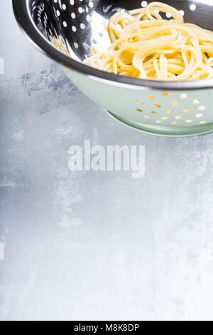 Fresche spaghetti cotti nel filtro in acciaio inox Foto Stock