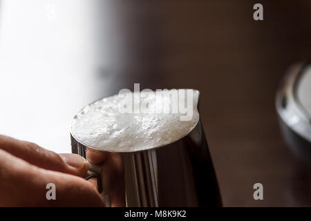 In mani maschio bricco per latte con panna di latte, close-up. Foto Stock
