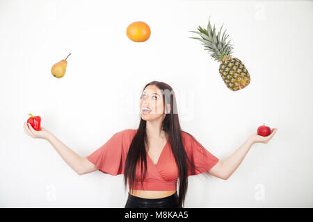 Una bella ragazza adolescente giocolare con i suoi cinque al giorno di frutta e verdura Foto Stock