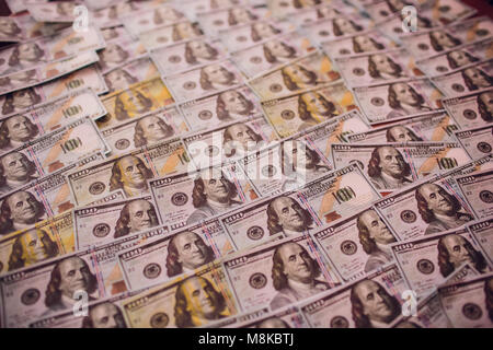 Centinaia di nuovi Benjamin Franklin 100 fatture del dollaro disposti in modo casuale con il ritratto affacciata superiormente in modo concettuale in materia finanziaria e monetaria backgro Foto Stock