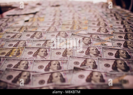 Centinaia di nuovi Benjamin Franklin 100 fatture del dollaro disposti in modo casuale con il ritratto affacciata superiormente in modo concettuale in materia finanziaria e monetaria backgro Foto Stock