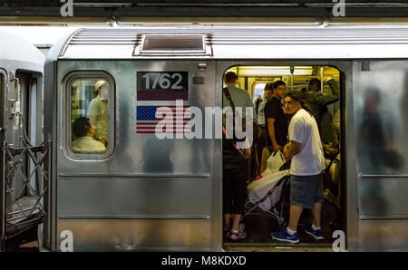 Un treno della metropolitana di New York affollato di persone alla stazione della metropolitana di Queensboro Plaza, Queens, New York Foto Stock