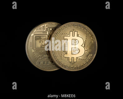 Due Golden bitcoins su uno sfondo nero. denaro elettronico isolato Foto Stock