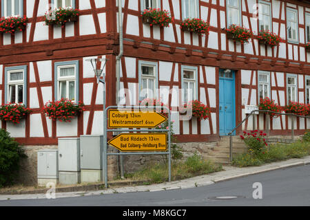 Ummerstadt, Germania. Giallo segni di direzione nella parte anteriore del graticcio casa. (Dettaglio) Foto Stock