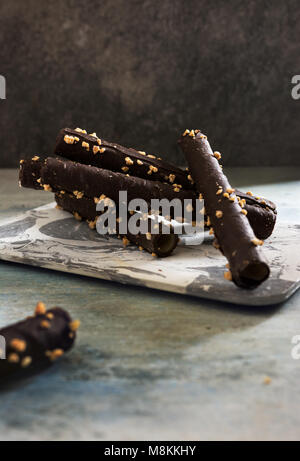 Fetta panini al cioccolato con mandorle, in calcestruzzo geometrico ciotola, su sfondo grunge. Foto Stock