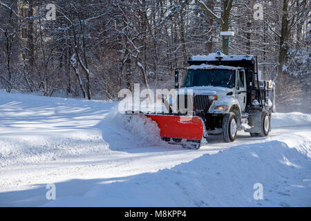 Snow Plough carrello in movimento cancellazione di una strada comunale, street, dopo la nevicata presso la Western University di Londra, Ontario, Canada. Foto Stock