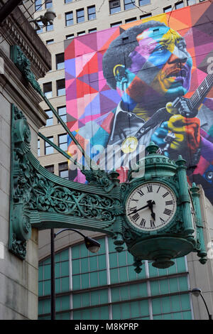 Oltre cento-anno-vecchio Marshall Fields orologi e un più recente murale di Blues grandi acque fangose su State Street a Chicago. Foto Stock