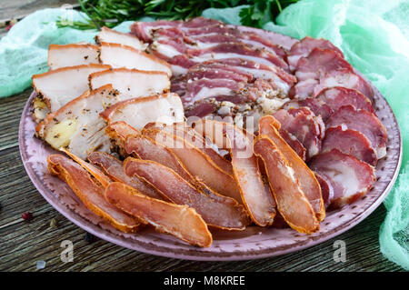 Grande set di carne. In casa di carne di maiale affumicata-salsicce di manzo, Pancetta salata, basturma fette tagliate su una tavola di legno con le spezie e le erbe. Foto Stock
