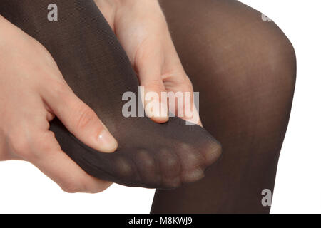Close-up del piede femminile con il collant. La donna è strofinando il dita per rilassarsi il dolore. Foto Stock