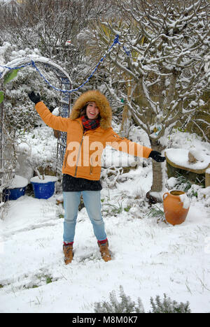 Portland, Dorset. 18 Marzo 2018 - raramente visto la neve sulla isola di Portland nel Dorset ! Una giovane donna con una cappa di pelliccia gode la novità. Credito: stuart fretwell/Alamy Live News Foto Stock