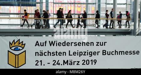 18 marzo 2018, Germania, Lipsia: i visitatori alla fiera del libro di Lipsia a piedi lungo un corridoio con un segno pubblicità della fiera. Foto: Sebastian Willnow/dpa-Zentralbild/dpa Foto Stock