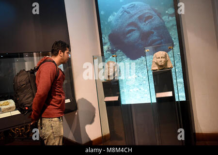 Alessandria, Egitto. Xviii Mar, 2018. Un visitatore guarda sunken antichità espone a Alessandria Museo Nazionale di Alessandria d'Egitto, il 12 marzo 2018. Alessandria Museo Nazionale, contenente alcune 1.800 inestimabili faraonica, greco-romane, islamica e copta artefatti che narrano la storia del Mediterraneo la storia della città di Alessandria a nord della capitale del Cairo, fu aperta al pubblico nel 2003. Credito: Zhao Dingzhe/Xinhua/Alamy Live News Foto Stock