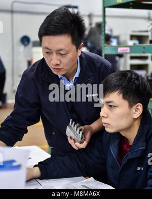 (180319) -- Pechino, 19 marzo 2018 (Xinhua) -- Yang Feifei (L) incarica il suo collega in una fabbrica in Guanlan Science Park di Foxconn Technology Group di Shenzhen, Cina del sud della provincia di Guangdong, 27 febbraio 2018. Yang Feifei proviene dalla campagna in città di Nantong, est cinese della provincia di Jiangsu. Egli era interessato in macchinari fin dall'infanzia ed è diventato un lavoratore tecnico in Foxconn Technology Group nel sud della Cina di Shenzhen dopo la laurea nel 2003. Yang ha messo la maggior parte del suo tempo a meditare su come ottimizzare il processo tecnologico e di migliorare la qualità del prodotto. Così facendo il suo innov Foto Stock