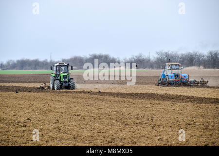 Rigogliosa e allentare il suolo sul campo prima della semina. Il trattore aratri un campo con un aratro Foto Stock