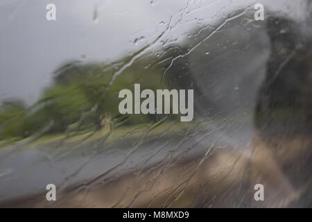 Giorno di pioggia nella finestra di bus con il gocciolamento di acqua dal vetro Foto Stock