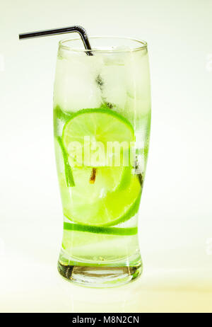 Estate bevanda fredda mojito lime e menta con ghiaccio e soda con gocce su un vetro su uno sfondo bianco Foto Stock