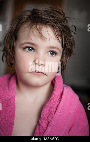 Triste ragazza in accappatoio con corti capelli bagnati a casa Foto Stock