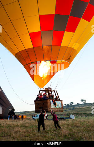Mongolfiera il gas di riempimento del bruciatore palloncino giallo con aria calda di decollare in volo. Partecipando a Canberra Hot Air Balloon Festival Foto Stock