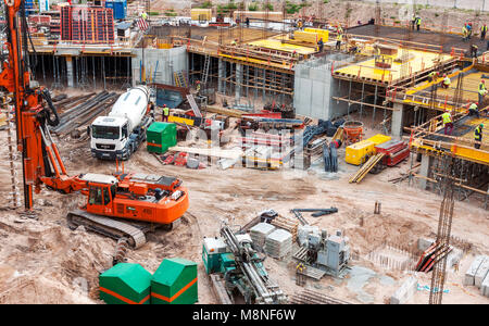 Una giornata intensa al sito in costruzione di macchinari, materiali da costruzione e dei lavoratori di Vilnius, Lituania Foto Stock