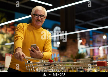 Senior uomo nel negozio di alimentari Foto Stock