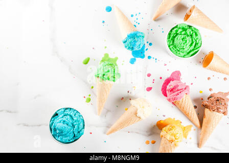 Diversi fatti in casa di ghiaccio in fusione la crema in ciotole e waffle coni gelato, bianco vaniglia, arancione, rosa berry, verde, blu, cioccolato bianco backg in marmo Foto Stock