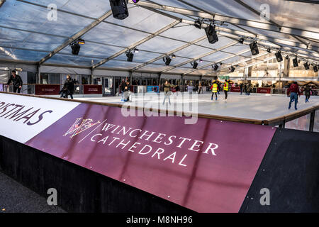 Pista di pattinaggio su ghiaccio durante il periodo natalizio istituito presso la Cattedrale di Winchester motivi, Hampshire, Regno Unito Foto Stock