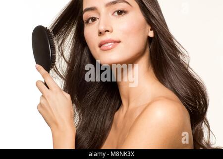 Modello rilasciato. Giovane donna brushing capelli lunghi marrone, ritratto. Foto Stock