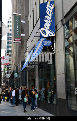 La linea è fuori dalla porta e giù per il marciapiede come linea di persone fino a comprare popcorn gourmet da Garrett il popcorn Shop fuori dal Magnificent Mile di Chicago. Foto Stock