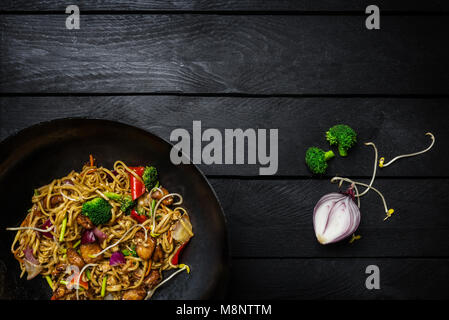 Friggere le tagliatelle in cinese tradizionale wok con ingredienti. Spazio per il testo. Foto Stock