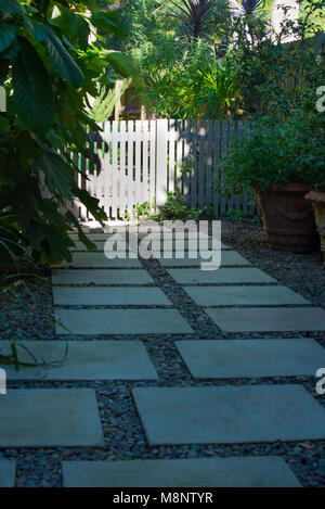 Un concreto trampolino di lancio e il sentiero di ghiaia che conduce a un dipinto di Picket Fence in North Shore giardino di Sydney, Australia Foto Stock