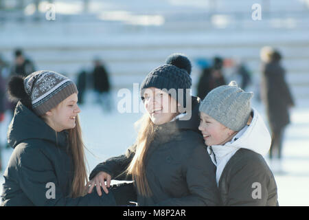 Ritratto di tre ragazze adolescenti che indossa abbigliamento invernale presso la pista Foto Stock
