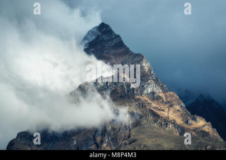 Montagne di nuvole nel cielo coperto sera in Nepal. Paesaggio con belle e alte rocce e drammatico cielo nuvoloso al tramonto. La natura dello sfondo. Fairy scen Foto Stock